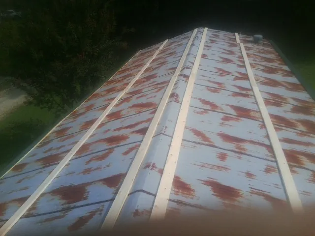 Rusted metal roof panels with new wood purlins before replacement — Storm Damage Roof Repair in Lawtell by Roofing Brothers